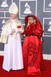 Nicki Minaj en los premios Grammy, acudió con una capa roja indescriptible y acompañada por un hombre vestido de Papa